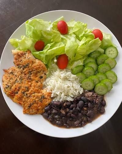 Prato com frango, arroz, feijão preto e salada